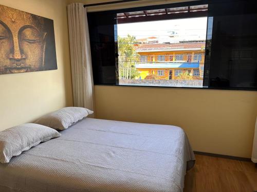 a bedroom with a bed and a large window at Casa duplex compacta Top in Guarapari