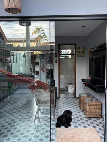 a black dog laying on the floor in a living room at Casa duplex compacta Top in Guarapari