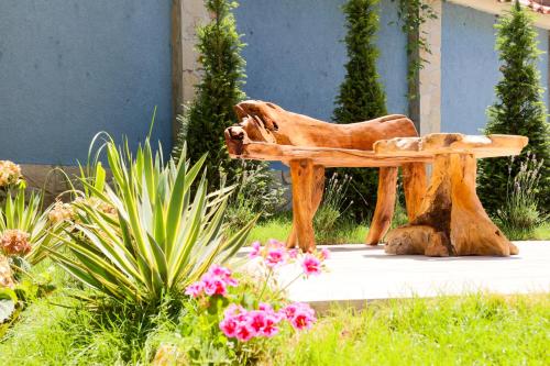 a wooden bench sitting in the middle of a garden at Tsarsko Selo Spa Hotel in Sofia