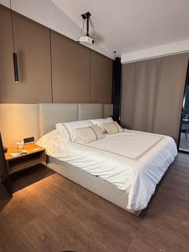 a bedroom with a large white bed with a side table at Suite en Viñedo in Arteaga