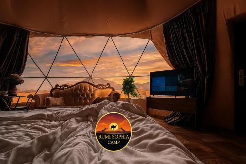 Dormitorio con cama y vistas a la puesta de sol en Rum Sophia camp, en Wadi Rum