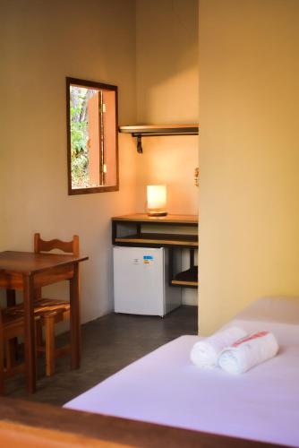 a room with a desk and a table and a bed at Hospedaria Lunar in Palmeiras