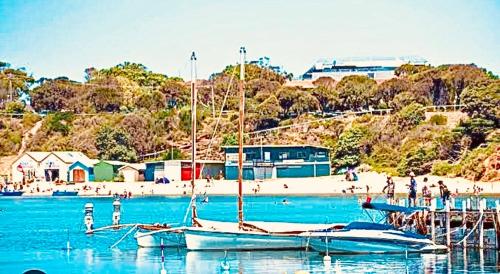 a boat docked at a dock with a beach at Heart of Mornington in Mornington