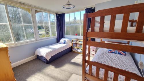 Dormitorio infantil con litera y ventanas en 15 Leamington Street, en Hanmer Springs