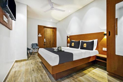 a bedroom with a large bed with a wooden headboard at Townhouse OAK Hi-City in Kamakhya