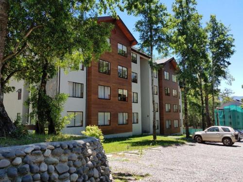 a building with a car parked in front of it at Departamento Acogedor Parque Suizo 800 Pucon in Pucón