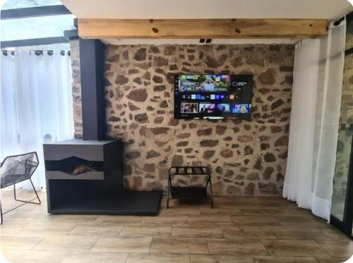 a living room with a stone wall with a stove at Cabaña Bruma in El Tepé