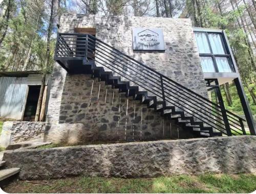 a stone building with stairs and a sign on it at Cabaña Bruma in El Tepé