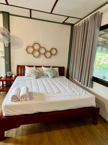 a bedroom with a bed with two towels on it at The Summer Guesthouse in Ban Khlong Son