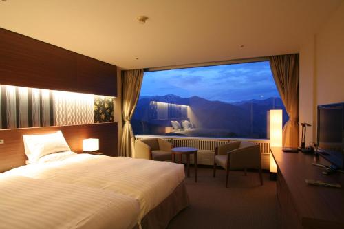 a hotel room with a bed and a large window at Minakami Kogen Hotel 200 in Minakami