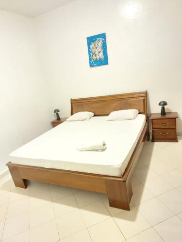a bedroom with a bed with a white mattress at Brise Résidentielle in Dakar