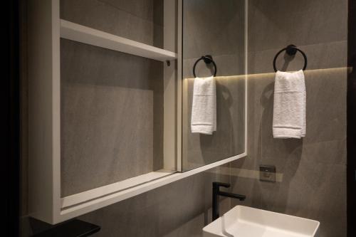 een badkamer met een wastafel en een spiegel bij Harmoni Lane Studios in Seminyak