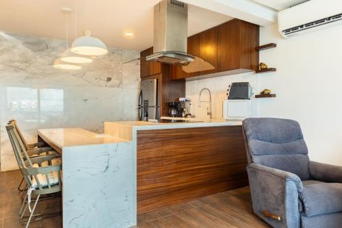a kitchen with a counter and a blue chair at Condominio Cancún Plaza in Cancún