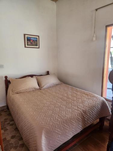 a bedroom with a bed in a room with a window at Wayra del Cerro in Purmamarca
