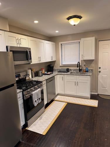 a kitchen with white cabinets and a stove top oven at Townhouse in Baltimore in Baltimore