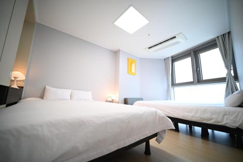 Un dormitorio con dos camas y una ventana. en Stay in WAVE, en Kwangan-dong