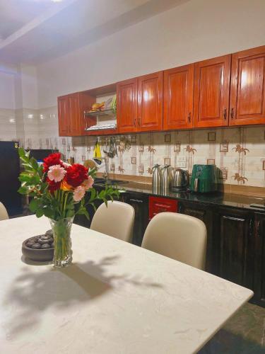 a vase of flowers sitting on a table in a kitchen at The Brownhaven Đà Lạt in Da Lat