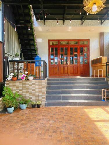 a front door of a building with stairs and plants at The Brownhaven Đà Lạt in Da Lat