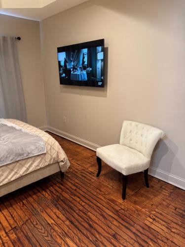 a bedroom with a bed and a chair and a television at Townhouse in Baltimore in Baltimore