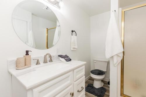 a white bathroom with a sink and a mirror at Hyde Park Haven - your home away from home - minutes north of Logan and USU in Hyde Park
