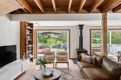 a living room with a couch and a fireplace at Coastal Soul in Narrawallee