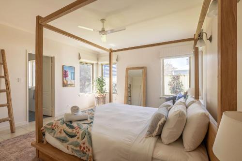 Un dormitorio con una cama grande con marco de madera. en Torretta by the Bay, en Dunsborough