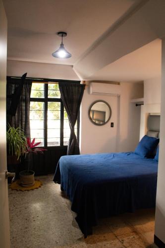 a bedroom with a blue bed and a window at Two-bedroom apartment with AC in the center Oaxaca in Oaxaca City