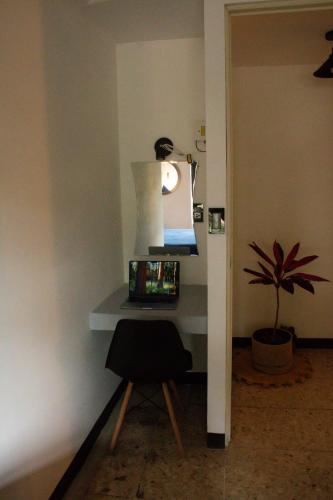 a desk with a chair in a room with a plant at Two-bedroom apartment with AC in the center Oaxaca in Oaxaca City