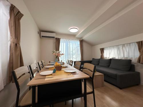 a living room with a table and a couch at nestay villa tokyo itabashi in Tokyo
