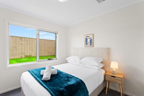 Un dormitorio blanco con una cama y una ventana. en Modern Family Home sleeps 8, en Wimbledon Heights