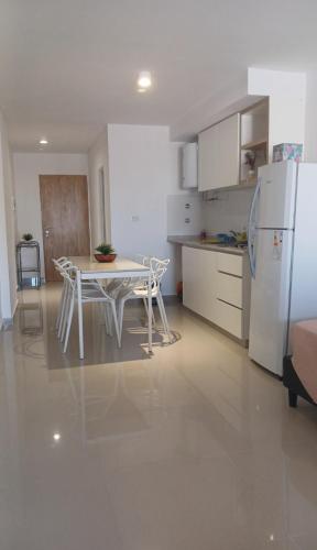 a kitchen with a table and a white refrigerator at Centro Suite SDE, confort y estilo moderno en el corazón de Santiago in Santiago del Estero