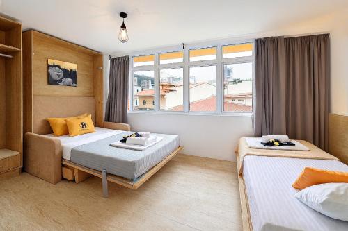 Una habitación de hotel con dos camas y una ventana. en hipstercity hostel, en Singapur