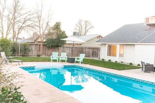 a swimming pool in a yard with chairs and a house at Charade House in Redding