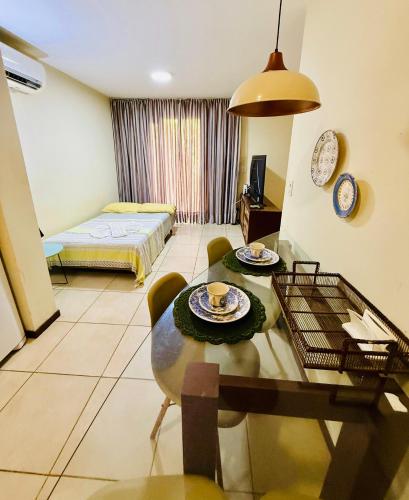 a living room with a table and a bed at Belo apartamento no Solar Pipa in Pipa