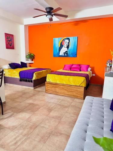 two beds in a room with an orange wall at Apt María Villa Lorena in La Paz