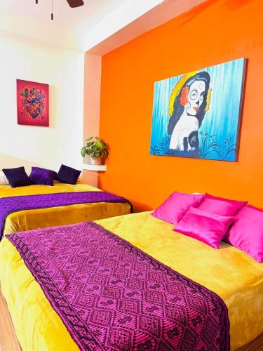 zwei Betten in einem Zimmer mit einem Gemälde an der Wand in der Unterkunft Apt María Villa Lorena in La Paz