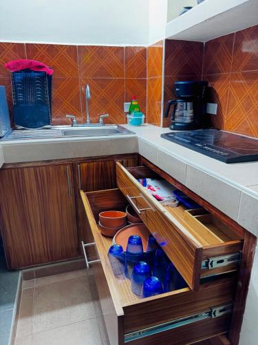 a kitchen with a sink and a drawer with water bottles at Apt María Villa Lorena in La Paz