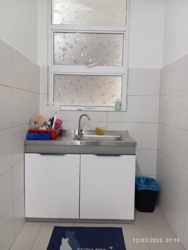 a white kitchen with a sink and a window at SR Sireh Residence in Kota Bharu