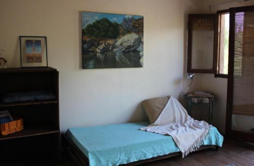 une chambre avec un lit avec un tableau sur le mur dans l'établissement Cabañas Bendita Tierra, à Los Molles