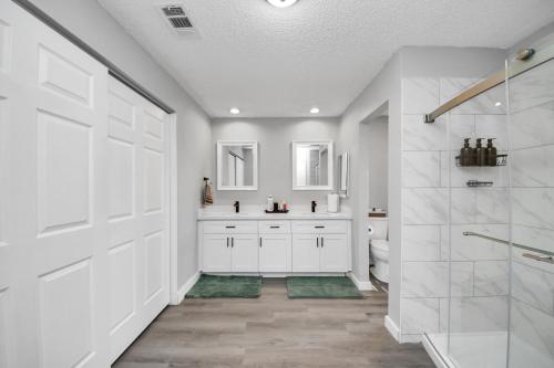 a white bathroom with a shower and a toilet at Cozy 3-bedroom bungalow in Richmond, TX in Richmond