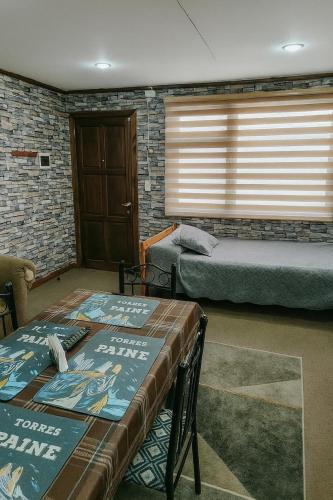 a bedroom with two beds and a table with a book at Cabañas Puerto Natales centro in Puerto Natales