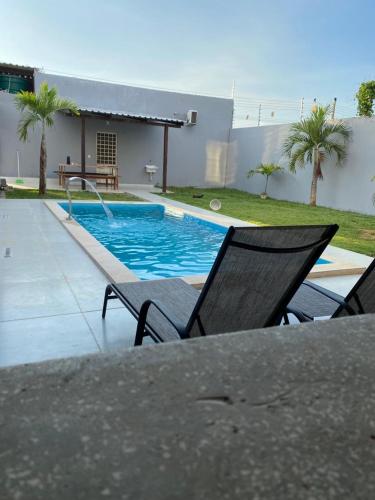 ein Pool mit einem Tisch und Stühlen daneben in der Unterkunft Espaço lazer in Itaquatiara