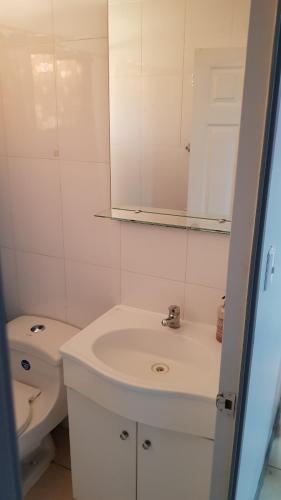 a white bathroom with a sink and a toilet at Casa en Graneros in Graneros