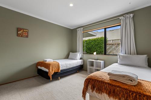 a bedroom with two beds and a window at Hideaway on Edgecumbe in Tauranga