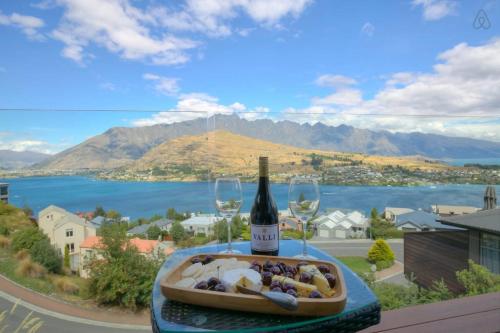 a bottle of wine and a bowl of food and wine glasses at Birch Haven Spa and Views in Queenstown