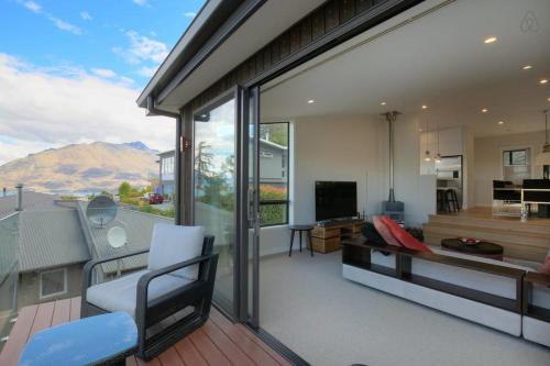 a living room with a view of a balcony at Birch Haven Spa and Views in Queenstown