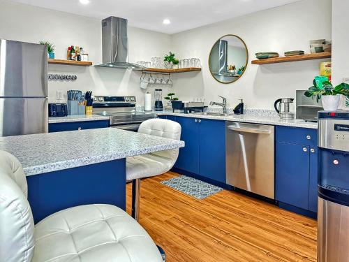 una cocina con armarios azules y electrodomésticos de acero inoxidable en Renovated Suite in WL, 5 Min to Downtown, All New Appliances, Self Check-In, en Williams Lake