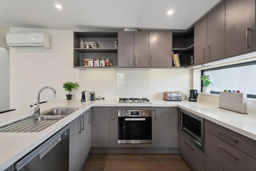 een keuken met een spoelbak en een fornuis bij Remarkable Lake View in Queenstown