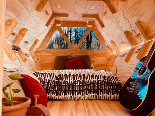 a living room with a couch and guitar in a tiny house at Surí refugios Villa O'Higgins, Fin de la Carretera Austral in Villa O'Higgins