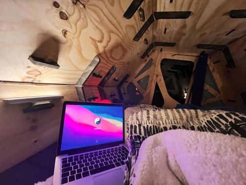 a laptop computer sitting on a bed in a room at Surí refugios Villa O'Higgins, Fin de la Carretera Austral in Villa O'Higgins
